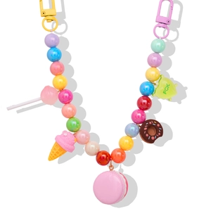 Colorful beaded keychain with dessert charms like ice cream cones and donuts on white background