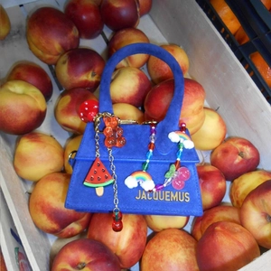 Blue suede mini bag with colorful beaded charms and fruit trinkets in a peach basket