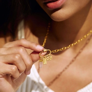 Detail of 18K gold-plated necklace with pink crystal and Cancer zodiac pendant