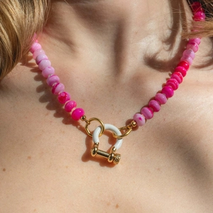 Nahaufnahme einer bunten Perlenkette mit goldenem D-Ring-Verschluss am Schlüsselbein