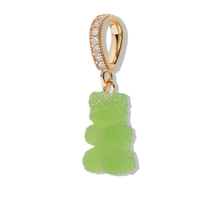 Macro shot of a green gummy bear charm with a gold sparkling rhinestone-set ring