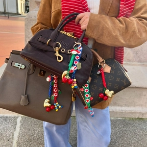 Colorful handmade cherry and heart bag charms with woven rope on luxury leather bags