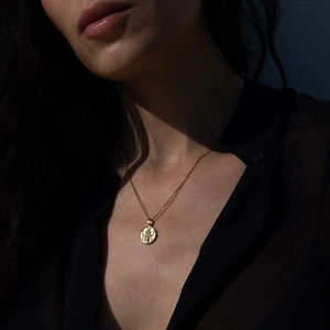 Nahaufnahme einer goldenen Münzhalskette im Vintage-Stil mit dramatischem Lichteffekt