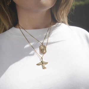 Details von mehrlagigen Goldketten mit Adler-Anhänger und geprägtem Faust-Rechteck-Charm