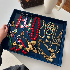 Detail view of colorful heart and cherry charms on a premium navy jewelry tray