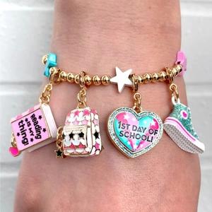 Close-up of beaded school charm bracelet with colorful backpack and book pendants