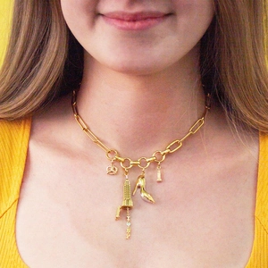 Macro shot of gold chain necklace with New York charms and I Love NY pendant detail