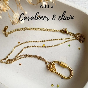 Detailansicht des goldenen Karabiner-Anhängers mit feiner Gliederkette als Zubehör