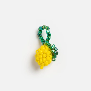 Pendentif serpent du zodiaque en perles jaunes avec accents verts sur fond blanc pur