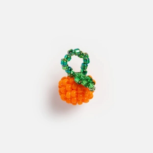 Vue macro détaillée du pendentif porte-bonheur en perles orange fait main avec feuilles vertes