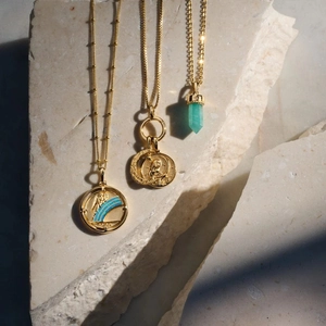 Vintage-Goldhalsketten mit Münzrelief, blauem Streifenteller und grünem Kristall