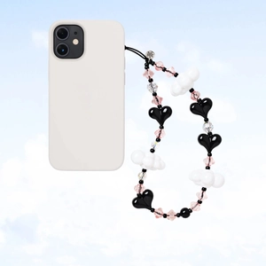 Detail of beaded phone strap with black hearts, clouds, and a metal brand tag on a white phone