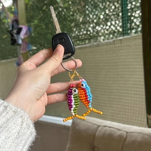 Detail view of colorful beaded fish keychains with vibrant patterns and metallic rings
