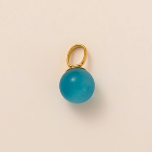Dettaglio macro di un pendente placcato oro 18K con pietra sferica blu traslucida
