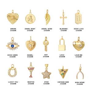 Collection of 15 gold stainless steel charms including heart, angel, and cross designs