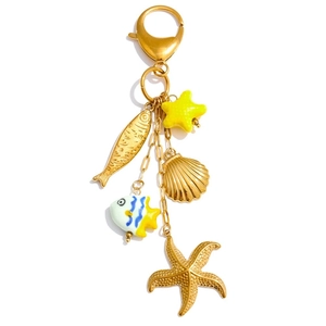 Detail of ocean-themed gold keychain featuring starfish shell and colorful enamel fish pendants
