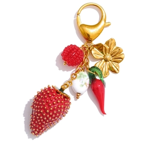 Detailed close-up of a pastoral charm keychain with strawberry, pepper and gold flower charms