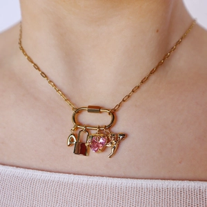 Gold paperclip chain necklace with pink heart gem, padlock, and cupid angel pendants