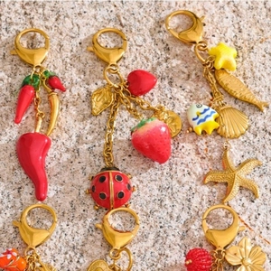 Summer keychain with colorful heart, strawberry, and starfish charms on a gold chain