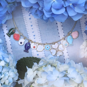 Ocean theme necklace with colorful enamel sea stars shells and fish pendants on a metal ring