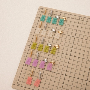 Colorful matte gummy bear pendants with four metallic clip options shown on a grid board