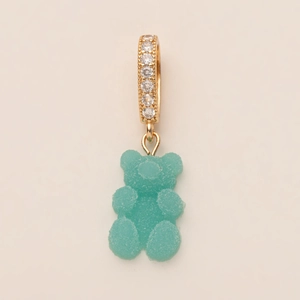 Macro shot of green gummy bear pendant with gold zircon-studded ring detail