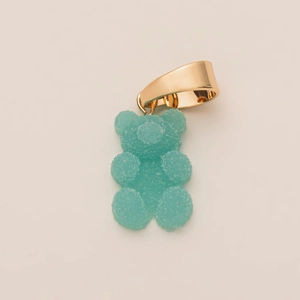 Close-up of mint green resin gummy bear pendant with sugar texture and golden clasp
