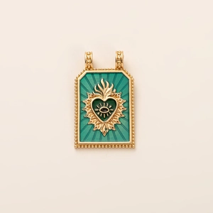 Detail of vintage tarot pendant with green enamel, gold heart, and evil eye motif