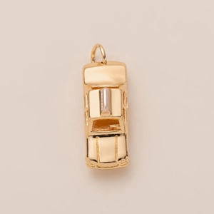 Détail d'un pendentif en forme de voiture dorée vintage avec finitions métalliques précises