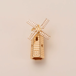 Pendentif moulin à vent doré détaillé avec des textures et motifs architecturaux complexes