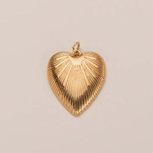 Detailopname van een hartvormige gouden hanger met radiale textuur en gepolijste glans