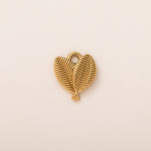 Macro detail of 18K gold plated shell pendant with parallel leaf texture and heart shape