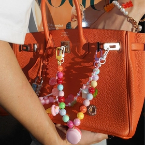 Bunter Perlen-Taschenanhänger mit Eiscreme und Donut Anhängern an einer orangefarbenen Tasche