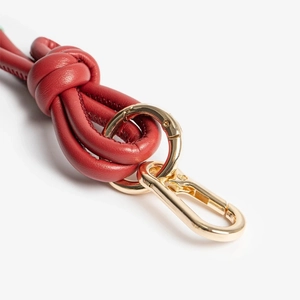 Detail of red leather handmade bead keychain with premium gold-tone metal ring clasp