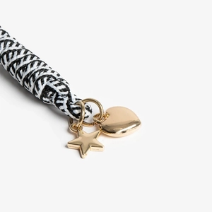 Detailed close-up of braided black and white cord with gold heart and star charms