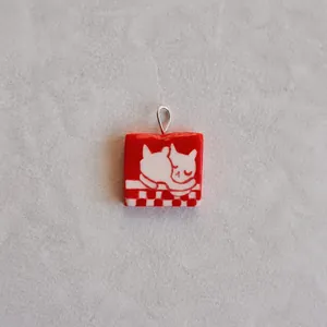 Detail of red square pendant with cute white cats on 18K gold plated necklace