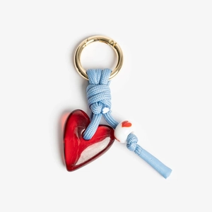 Close-up of red heart pendant with blue braided rope and golden metal ring