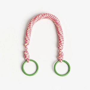 Detail of pink and yellow woven rope bag handle with green metal spring ring buckles