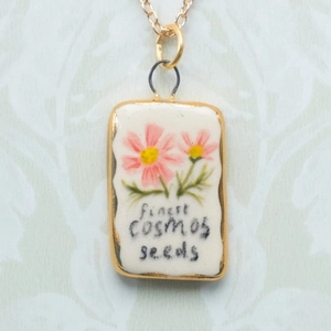 Collana minimalista placcata oro 18K con ciondolo in ceramica a fiori su tessuto bianco
