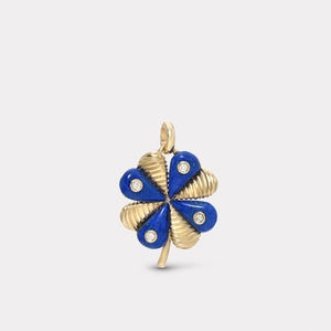 Détail macro d'un pendentif trèfle en or 18k avec lapis-lazuli et spirales gravées