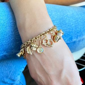 Macro détaillée d'un bracelet plaqué or 18K avec pendentifs miniatures de pâtisserie