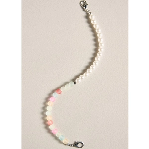 Gros plan d'une dragonne en perles faites main avec perles blanches et mates aux tons pastel