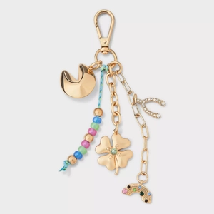 Detailed view of a gold keychain with fortune cookie, clover, and rainbow charms