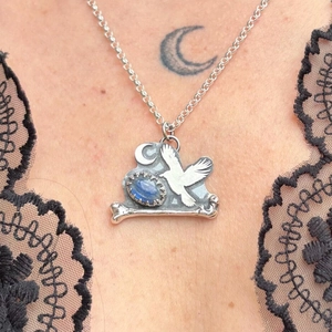 Dettaglio collana gotica vintage con ciondolo a corvo e luna e gemma blu incastonata