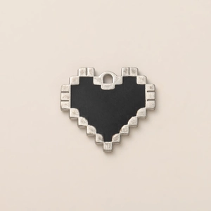 Vista macro di un ciondolo a cuore pixelato argentato con smalto nero e anello