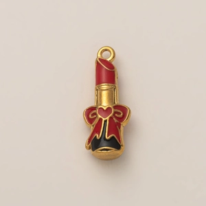 Dettaglio macro del ciondolo a forma di rossetto con cuore in smalto rosso e oro