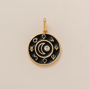 Detailed close-up of a 18K gold-plated round pendant with black enamel and moon stone