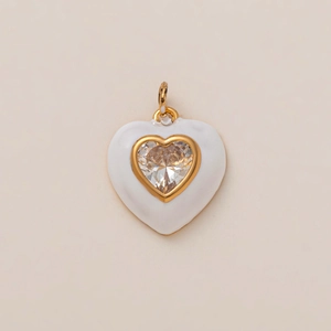 Macro detail of white enamel heart pendant with a centered zircon in 18K gold frame