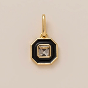 Close-up of octagonal gold pendant with black enamel inlay and square zircon gemstone