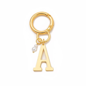 Detail of gold metal keychain with letter A charm and small pearl bead accessory
